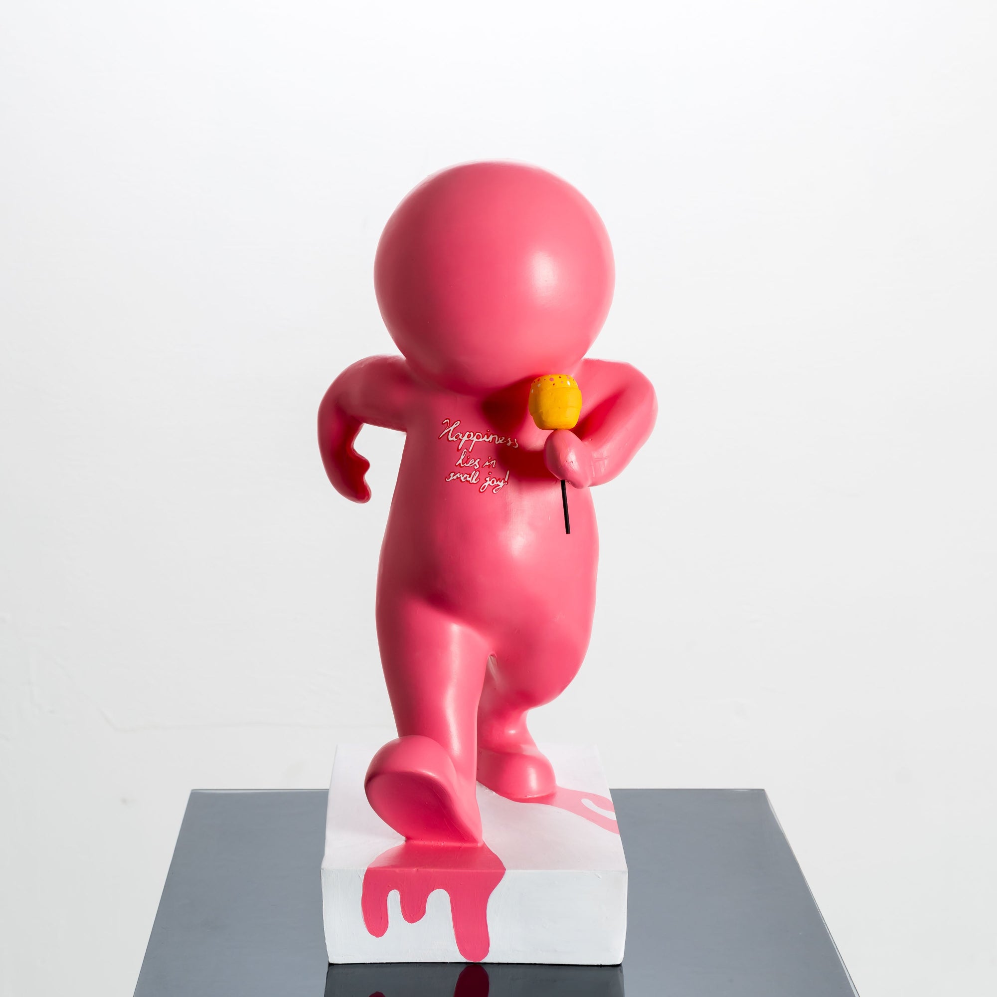 Pink statue with a yellow object on a white background